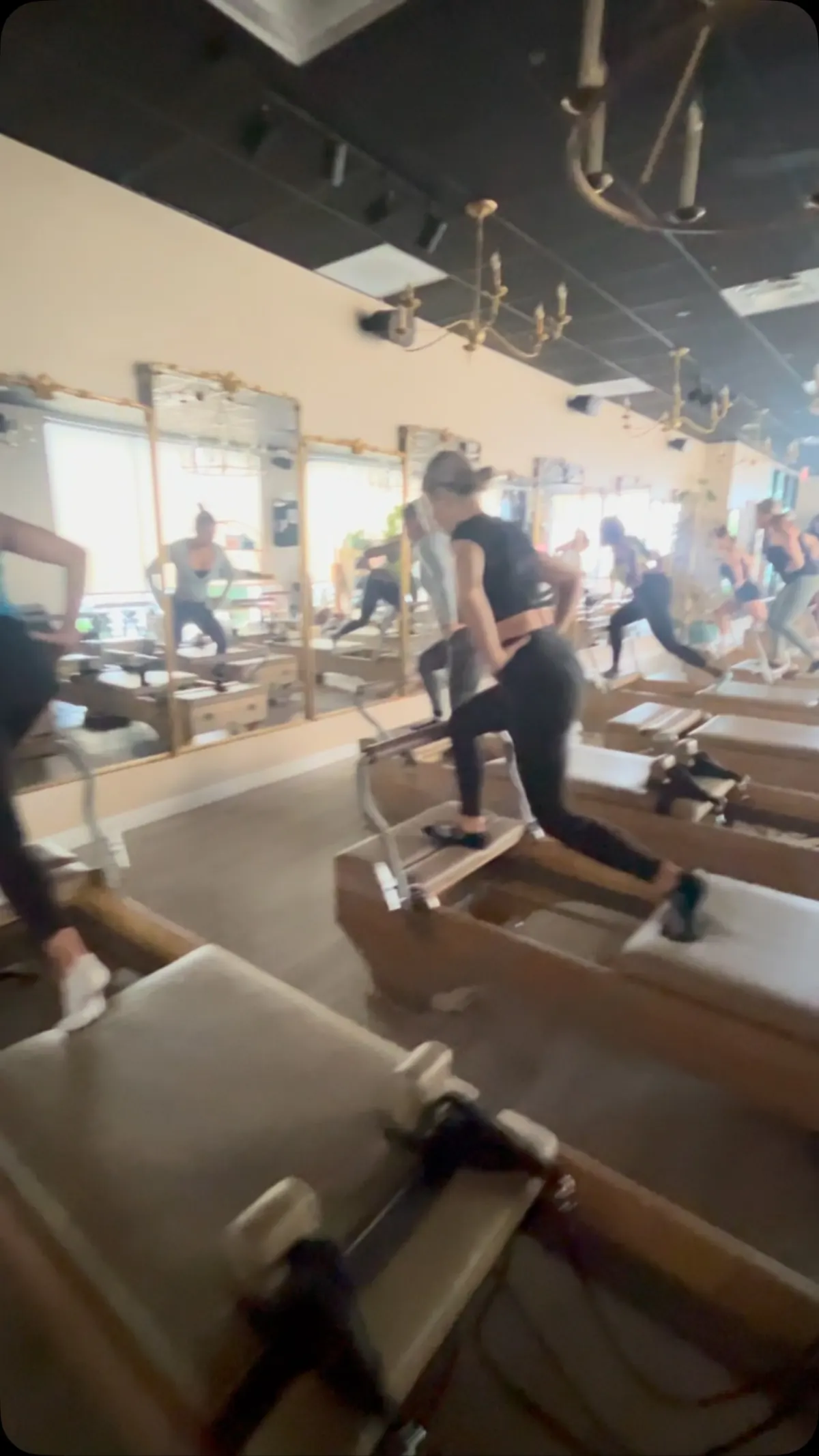 Clients in a standing lunge on the reformers, mid-class