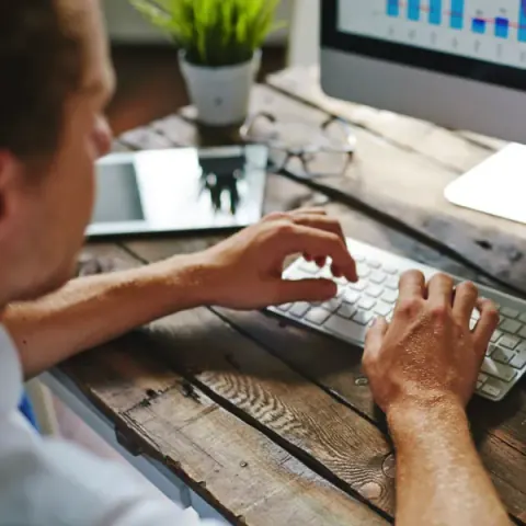 A front-desk team member working at a laptop